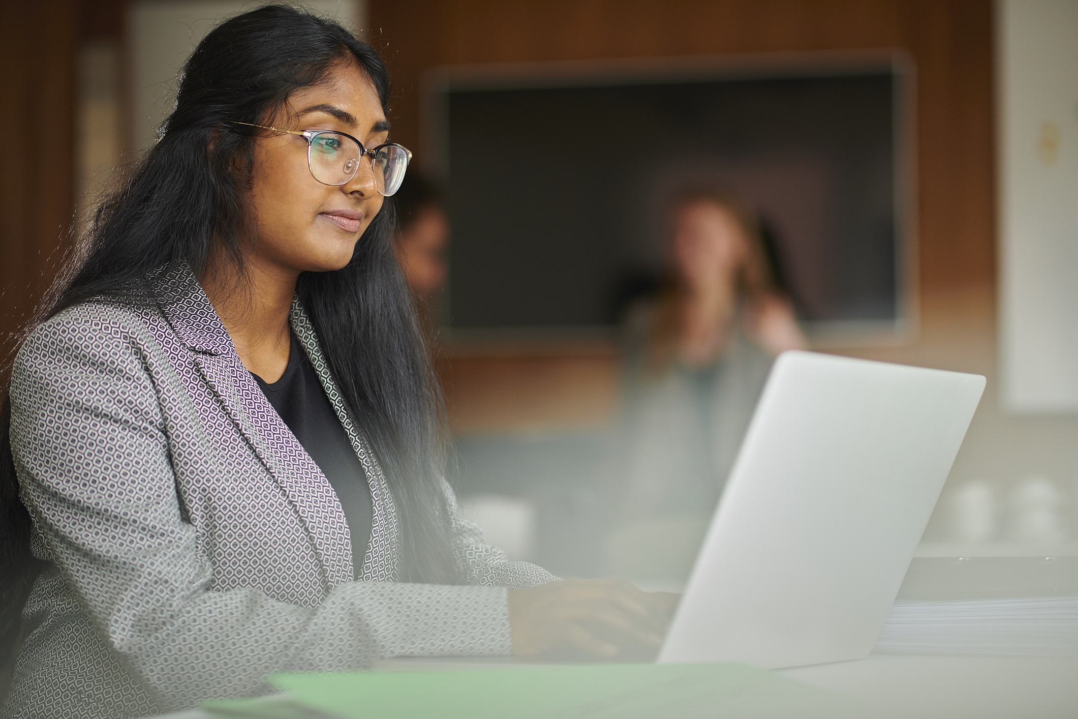 Student using laptop in classroom setting